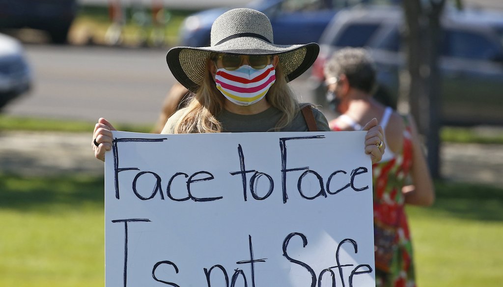 Kris Reddout, a 5th grade teacher, attends a rally at the Utah State Capitol as the state prepares to reopen classrooms this fall. (AP Photo/Rick Bowmer)