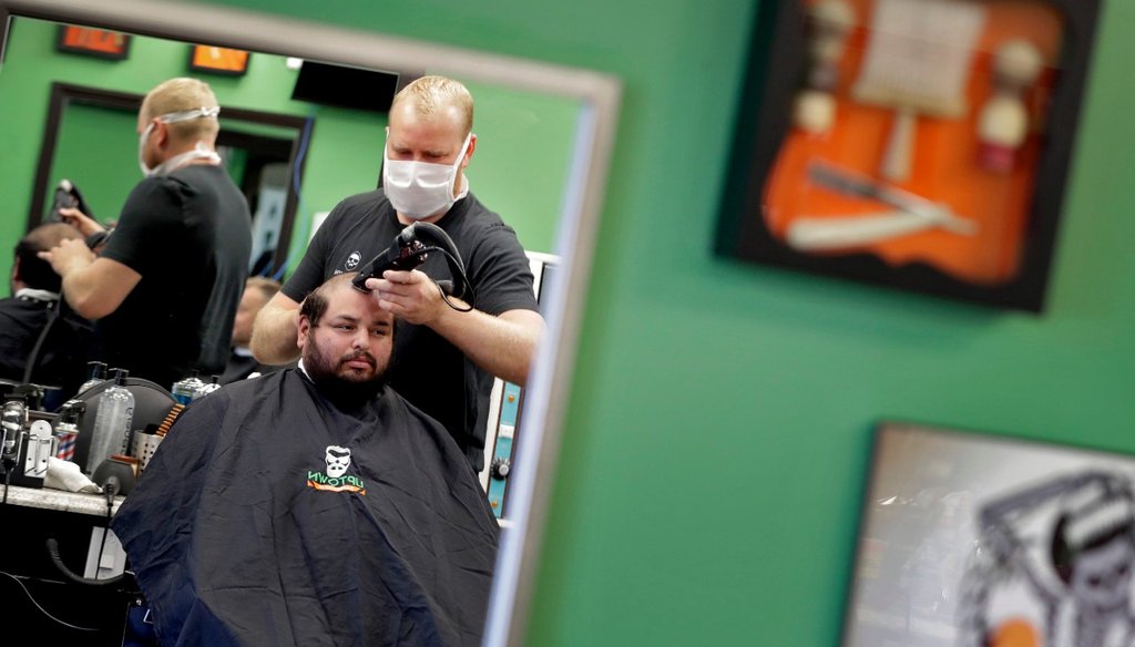 Jeff Guebara gets his hair cut by Roman Naumenko at Uptown Barbershop Friday, May 8, 2020, in Phoenix. Hair salons and barbershops across Arizona began reopening Friday after being closed for more than a month by order of the governor (AP Photo/Matt York)