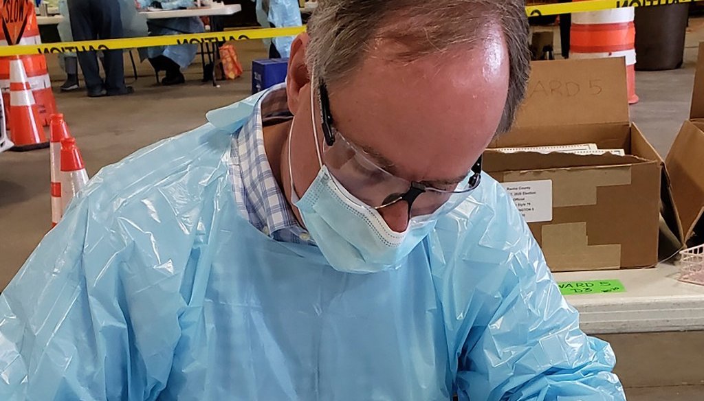 Robin Vos, the Republican speaker of the Wisconsin Assembly, is shown wearing a mask, gloves and a protective gown while working at the polls in Burlington, Wis., on Tuesday, April 7, 2020.