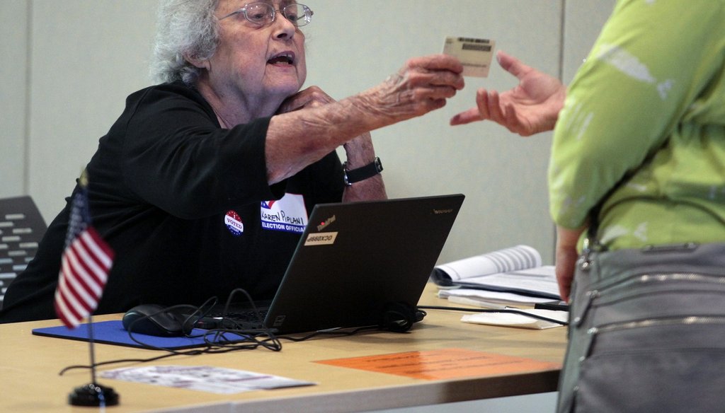 A precinct official in Chapel Hill, NC checks a photo ID in 2016.