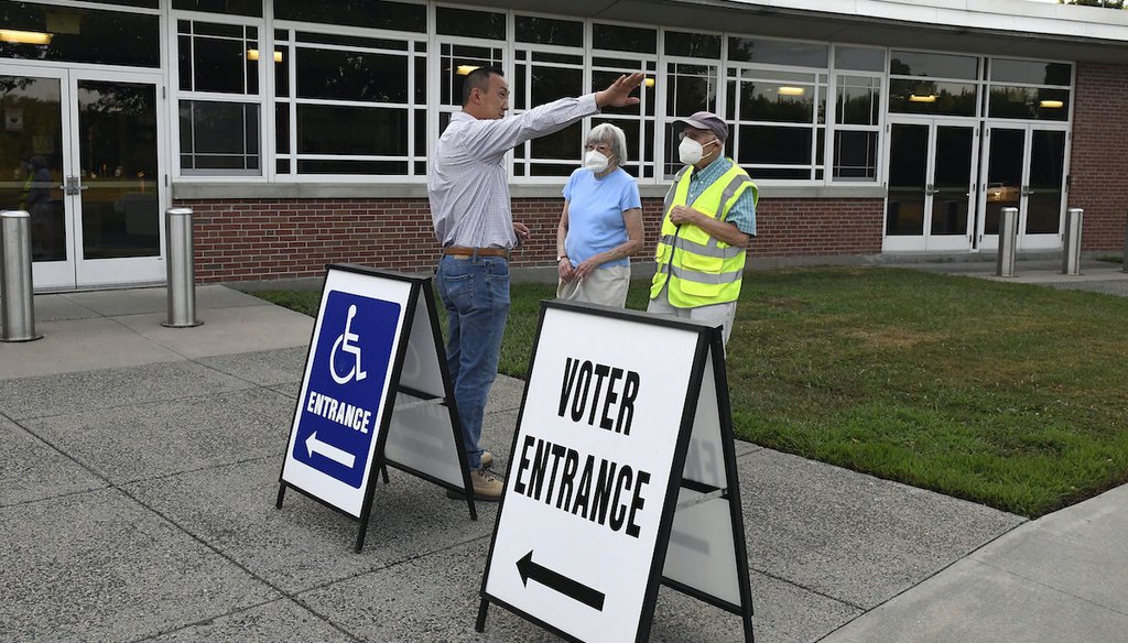 Republican First Selectman Colin Moll, left, talks with Suffield residents Richard and Connie Davis before they vote in the state's on primary election, Tuesday, Aug. 9, 2022, in Suffield, Conn.