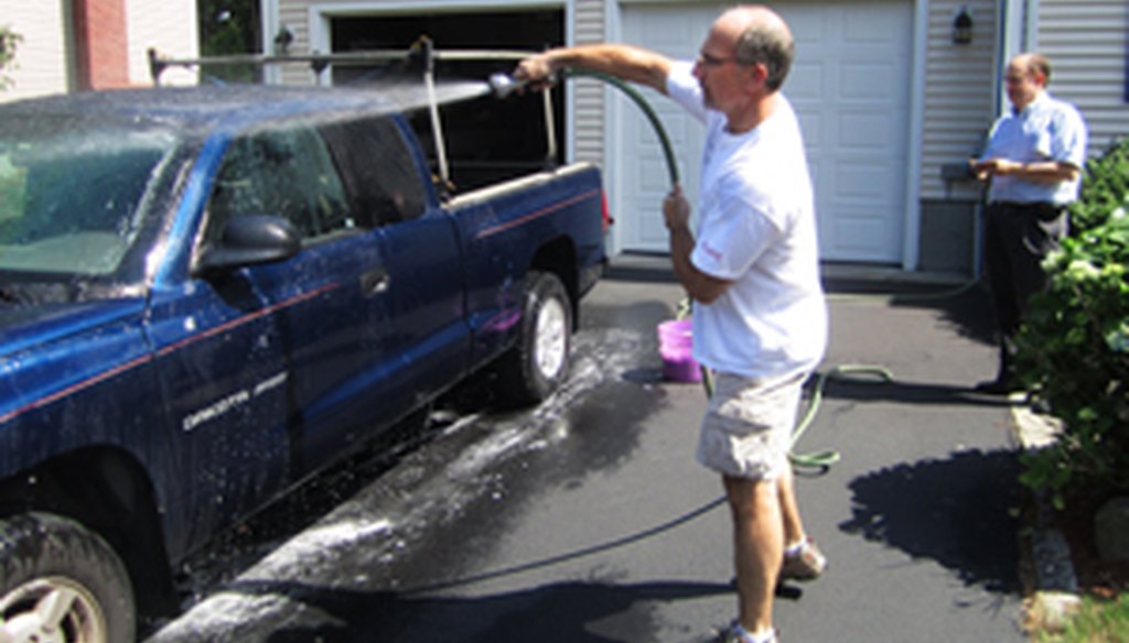 PolitiFact car wash experts Tom Mooney (with the hose) and Gene Emery (watching the time) do their experiment.