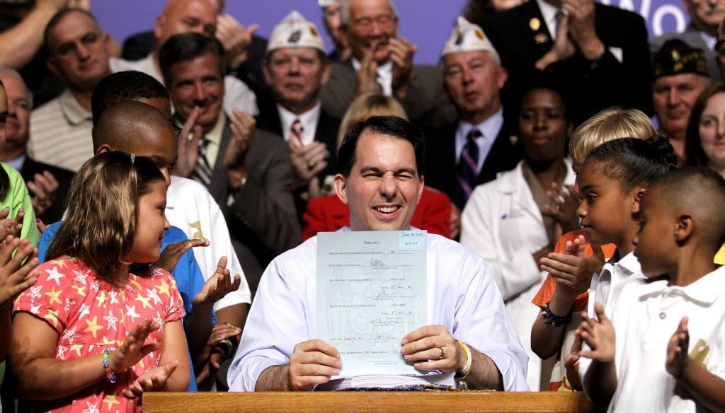 Gov. Scott Walker winks at the crowd after signing the 2013-'15 state budget.