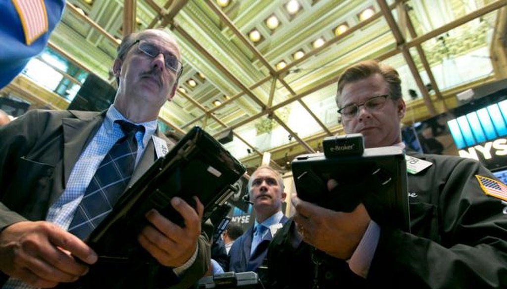 Traders Joseph Dente, Timothy Nick and Steven Capo work on the floor of the New York Stock Exchange on Aug. 4, 2015. (AP/Richard Drew)