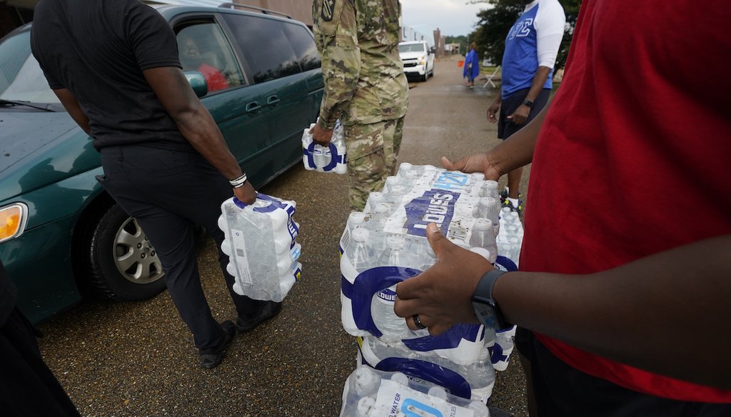 Volunteers distribute cases of water at a community/fraternal drive-thru water distribution site in Jackson, Mississippi, Sept. 7, 2022. (AP).