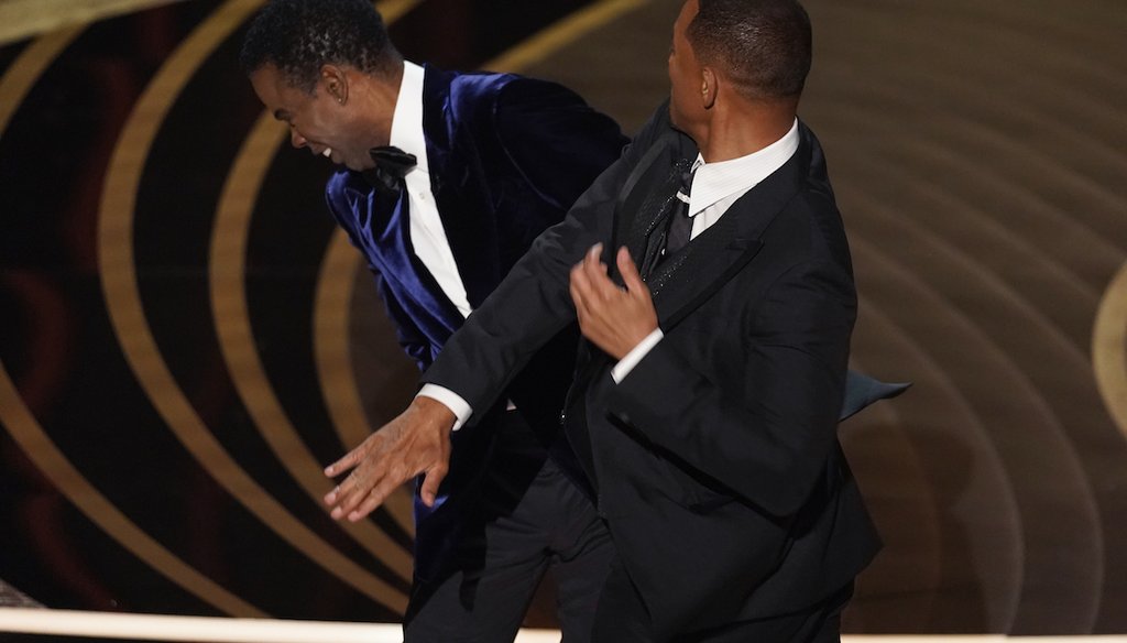 Will Smith, right, hits presenter Chris Rock on stage at the Oscars on March 27, 2022. (AP)