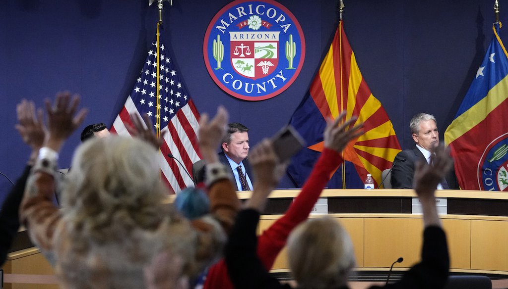 People stand in protest to the Maricopa County Board of Supervisors during their general election canvass meeting Nov. 28, 2022, in Phoenix. (AP Photo/Matt York)
