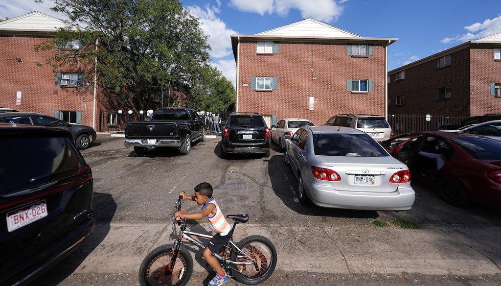 A boy guides his bicycle past apartment buildings Sept. 3, 2024, during a rally staged by the East Colfax Community Collective to address chronic problems in the apartment buildings in Aurora, Colo. (AP)