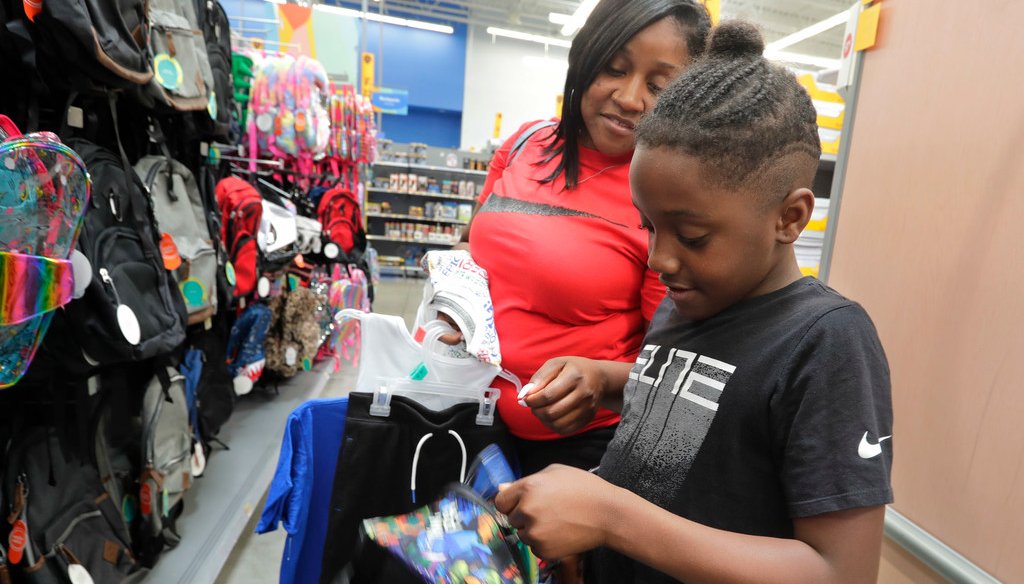 Carolyn Harris helps Nyzer Pendleton, 10, buy a backpack for school Friday at the Super Walmart in Greendale. He chose a backpack for when he starts school in Milwaukee in the fall. (Photo: Rick Wood / Milwaukee Journal Sentinel