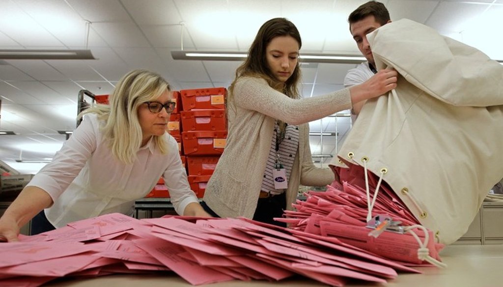 Election workers Heidi McGettigan, left, Margaret Wohlford, center, and David Jensen, unload a bag of ballots brought in a from a polling precinct to the Sacramento County Registrar of Voters office in Sacramento, Calif. Associated Press file photo.