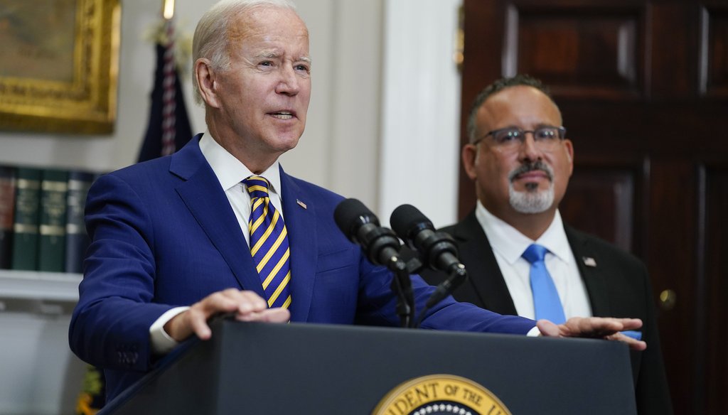 President Joe Biden speaks about student loan debt forgiveness at the White House on Aug. 24, 2022, as Education Secretary Miguel Cardona listens. (AP Photo/Evan Vucci)