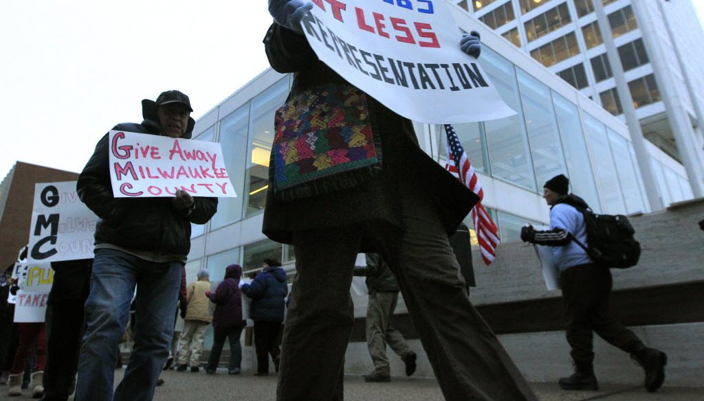 Picketers protested a proposal to sharply cut Milwaukee County supervisor salaries and slash the board's budget on January 24, 2012. They marched outside an event hosted by the Greater Milwaukee Committee, which backed the proposal. 