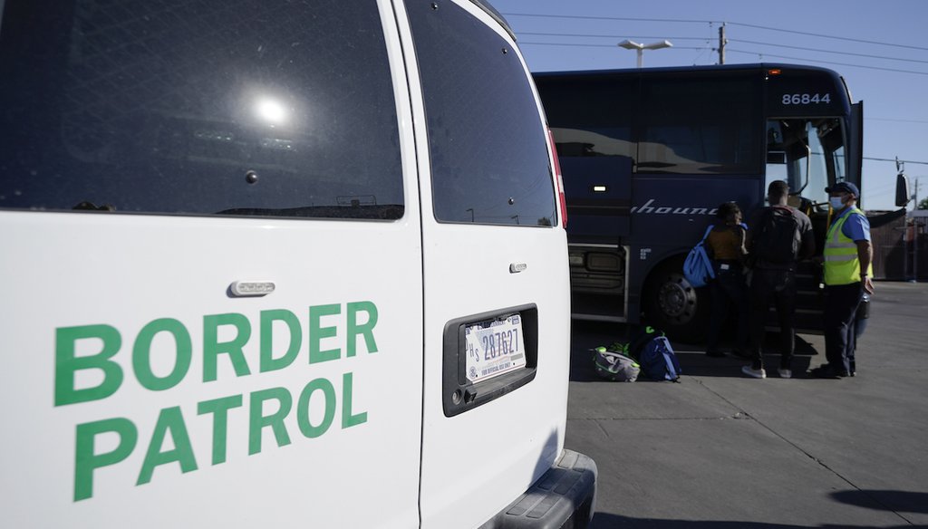 A U.S. Customs and Border Protection van is seen next to a bus picking up travelers, mostly migrants from Haiti released from CBP custody, at a gas station that serves as a bus terminal, Sept. 23, 2021, in Del Rio, Texas.