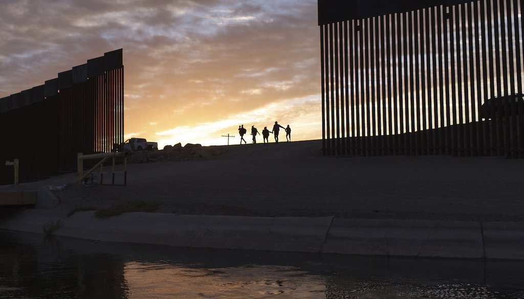 A pair of migrant families from Brazil pass through a gap in the border wall to reach the United States after crossing from Mexico in Yuma, Ariz., on June 10, 2021, to seek asylum. (AP)