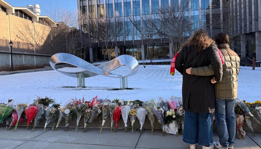Brown University senior Zoe Kass and her boyfriend return Dec. 16, 2025, to the engineering building they fled during a shooting to leave flowers in Providence, R.I. (AP)
