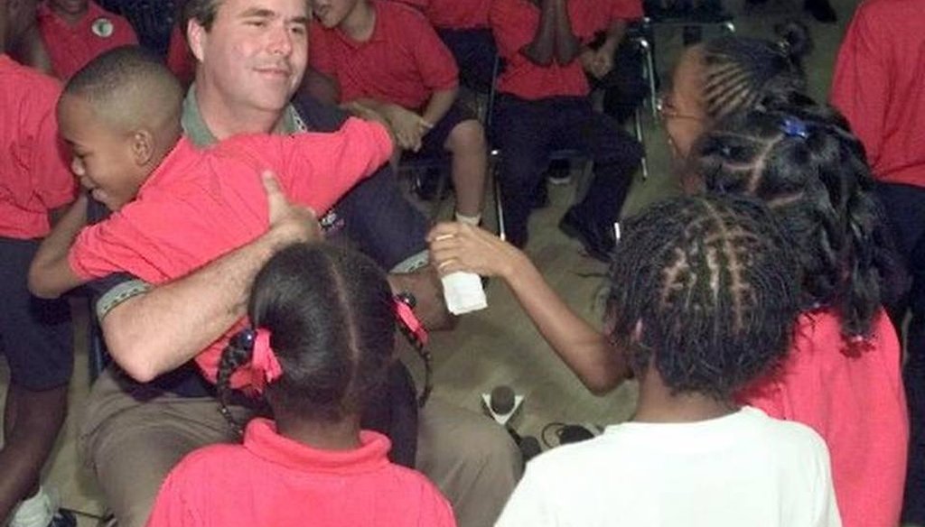 In 1998, Jeb Bush, then governor-elect, visited students at Liberty City Charter School which he co-founded. The school later closed. (AP) 