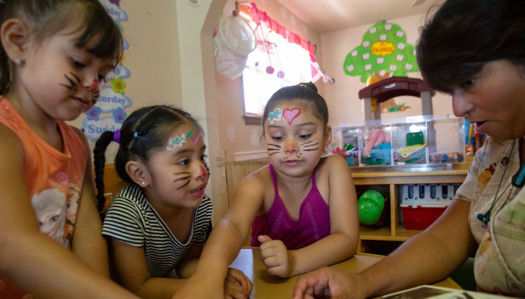 Maria Moreno reads to Mia Lopez (4), Ariana S‡nchez (3) and Leyla Lopez (6) at her daycare, Happy Faces Child Care in Milwaukee, in July 2019. File photo