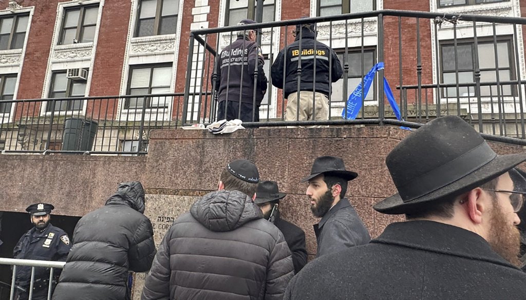 City inspectors and police officers outside the Brooklyn borough, N.Y., headquarters of the Chabad movement on Jan. 9, 2024. (AP)