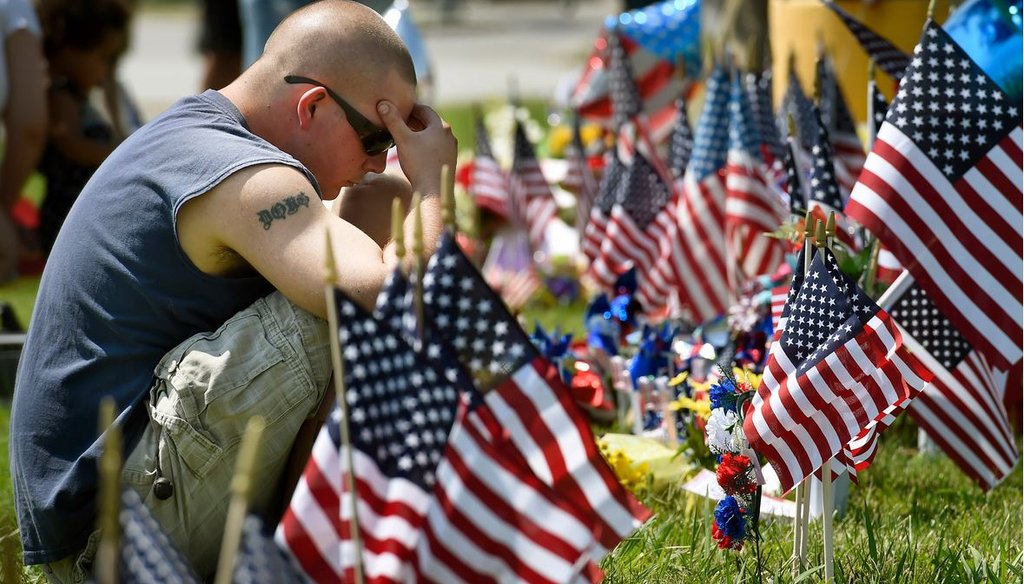 Douglas Debrs prays by a makeshift memorial outside the Armed Forces Career Center on Friday, July 17, 2015, in Chattanooga, Tenn. (AP Photo/Mark Zaleski) 
