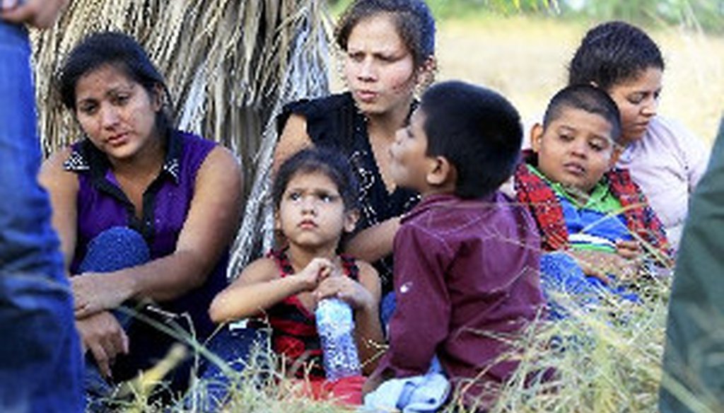 A group of 22 migrants, mostly women and children from Honduras and Guatemala, in custody just after crossing the Rio Grande near McAllen, Texas, June 18, 2014. (Jennifer Whitney/The New York Times)