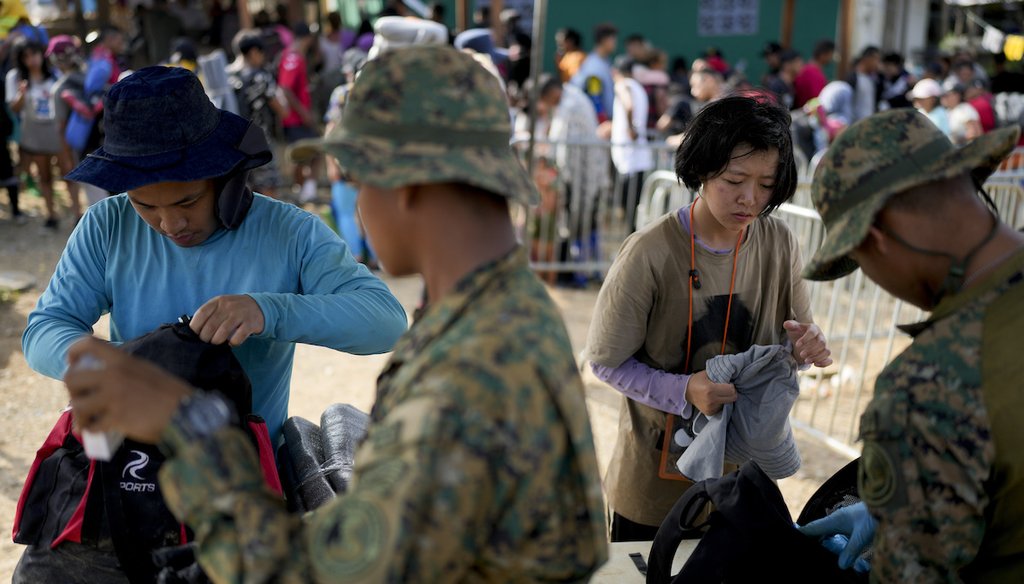Panamanian border police check Chinese migrants who walked across the Darién Gap from Colombia, upon their arrival in Bajo Chiquito, Panama, on May 6, 2023. (AP Photo/Natacha Pisarenko)