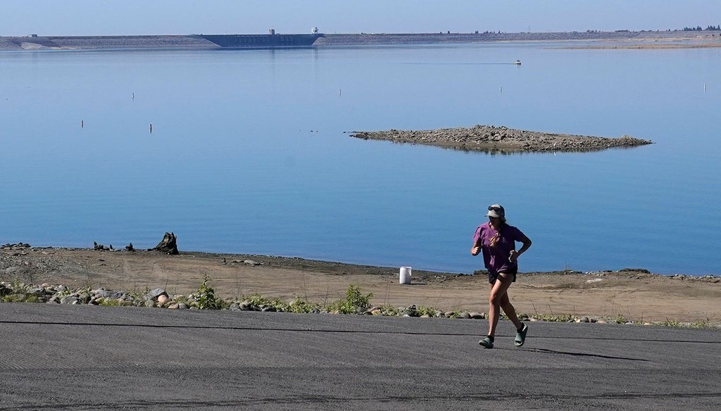 A jogger runs up a boat ramp that is normally underwater in Folsom, Calif., on Oct. 3, 2022. Widespread drought in large parts of Europe, the United States and China this past summer was made 20 times more likely by climate change, a new study shows. (AP)