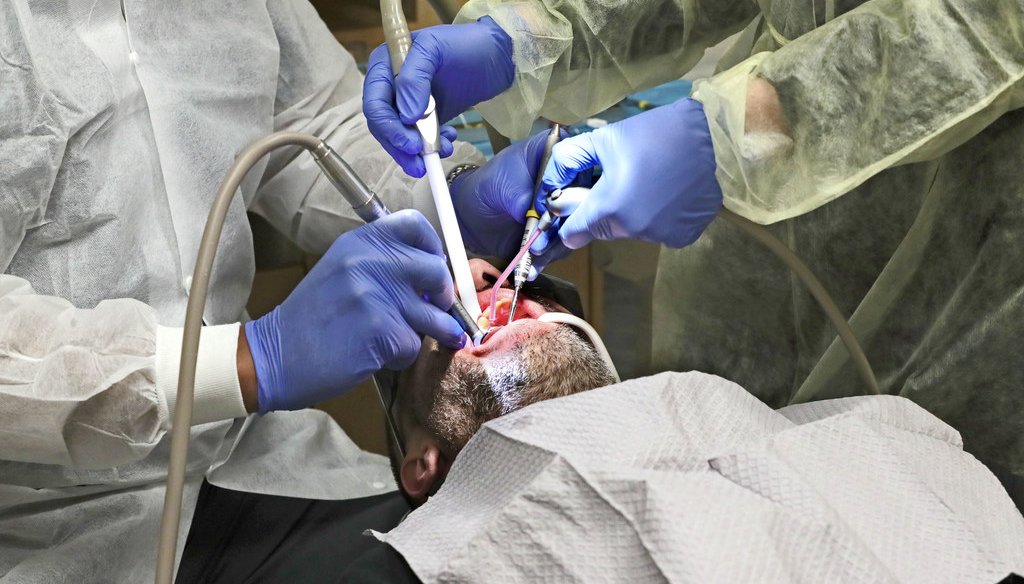Dentist Pablo Fernandez, left, does a dental filling at Lake Area Free Clinic in Oconomowoc in May 2019. (Photo by Michael Sears/Milwaukee Journal Sentinel)