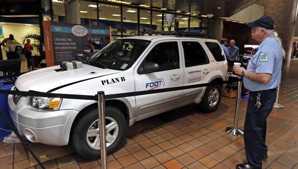 Anthony Ruvalo checks out the driverless car, Plan B, being demonstrated and on display at the Miami-Dade Government Center lobby on March 31, 2016. (Miami Herald)