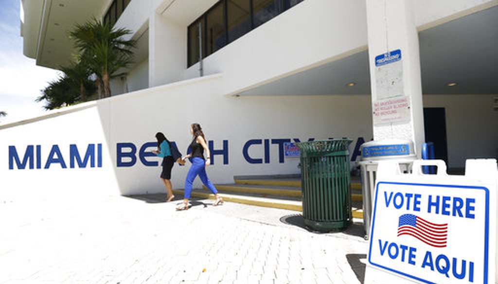 Pedestrians walk past a sign for a polling station at Miami Beach City Hall, Monday, Aug. 13, 2018, in Miami Beach, Fla. (AP)