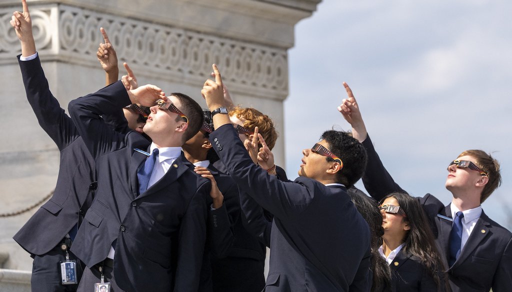 Senate pages wearing eclipse glasses view the solar eclipse in front of the U.S. Senate on Capitol Hill on April 8, 2024, in Washington. (AP)
