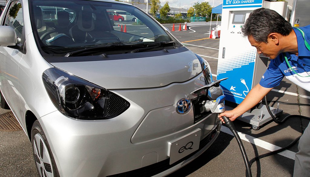 A Toyota Motor Corp. press event participant puts a quick charger plug into the newly-developed compact electric vehicle "eQ" during a test drive Sept. 24, 2012, at a press event in Tokyo. (AP)