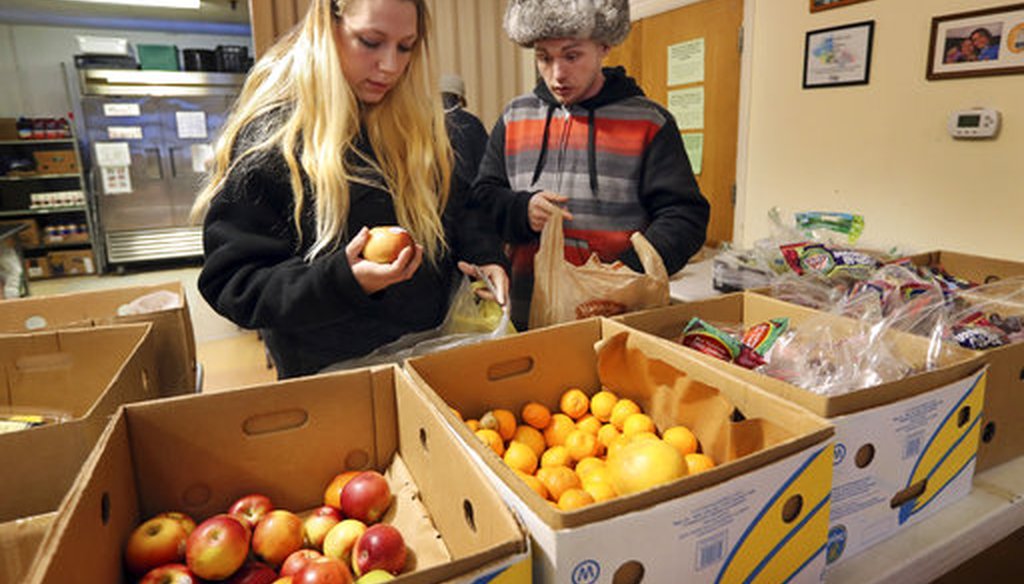 In this Monday, March 27, 2017 photo Sunny Larson, left, and Zak McCutcheon pick produce while gathering provisions to take home at the Augusta Food Bank in Augusta, Maine. (AP)