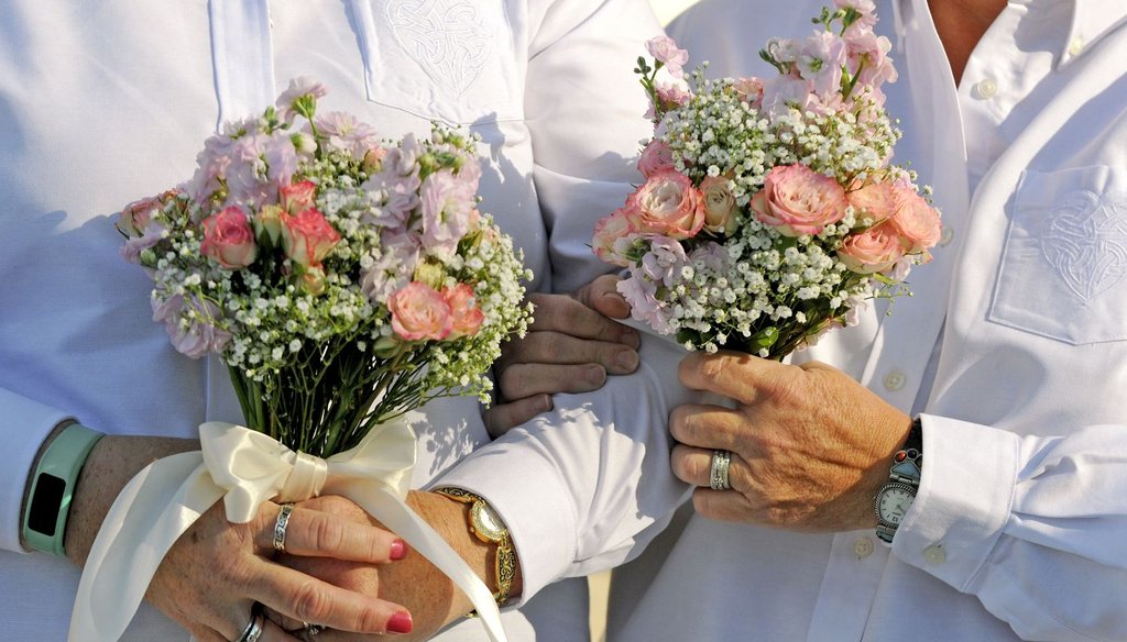 A couple holds matching bouquets as they are married in front of the Duval County Courthouse on Jan. 6, 2015, in Jacksonville, Fla. (AP Photo)