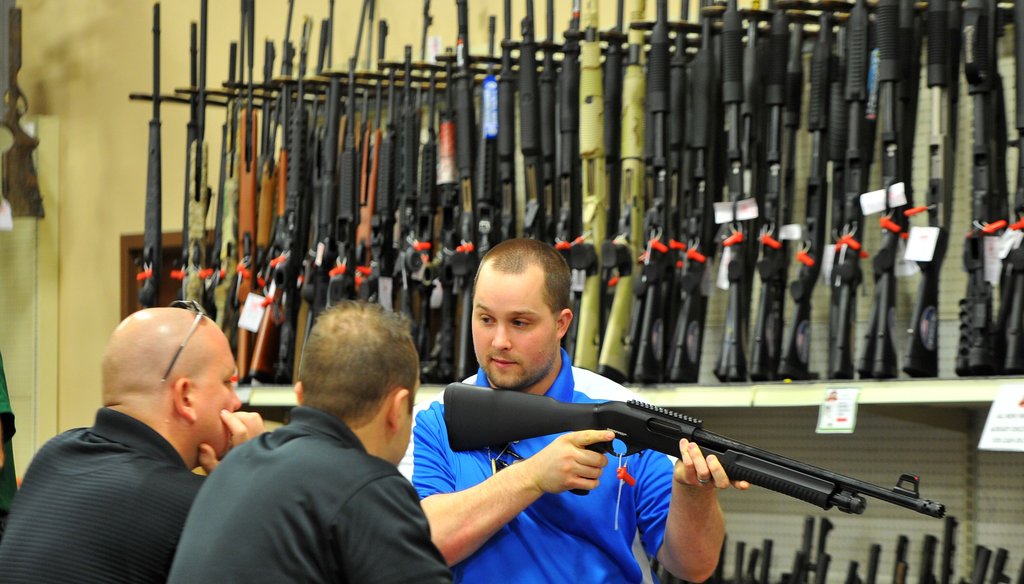 Adventure Outdoors salesman Adam James shows a shotgun to customers. The Smyrna, Ga. gun shop, shooting range and outdoor supply facility saw a 300 percent increase in gun sales shortly after the July 2012 movie theater shootings in Colorado.