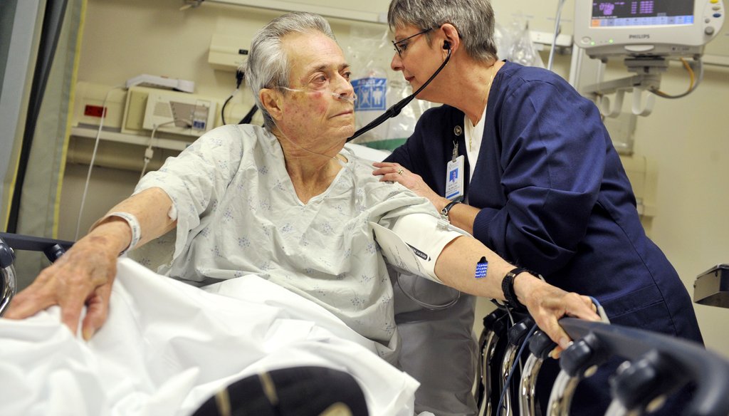 Piedmont Hospital nurse Kathy Flood (right) listens to patient Clarence Dee Holland's breathing to check for signs of pneumonia.
