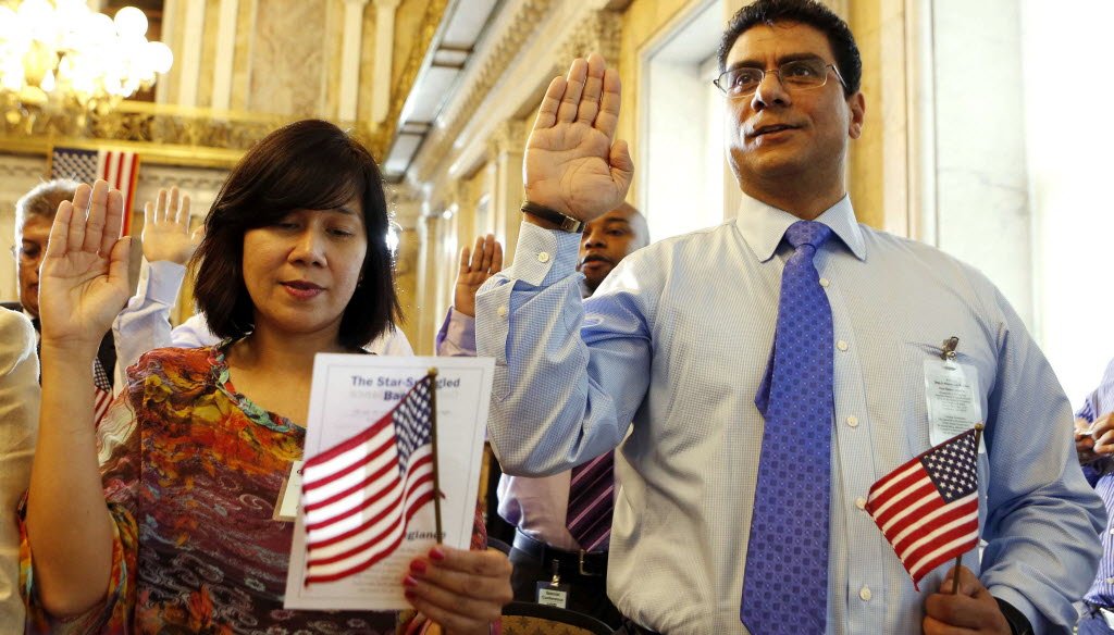 Candidates Noor Mononutu (on left) and Ashraf Mokhtar (on right) swear in as United States citizens during a Special Naturalization Ceremony for 30 U.S. citizen candidates at the U.S. Treasury Department in Washington, July 3, 2013. REUTERS/Larry Downing