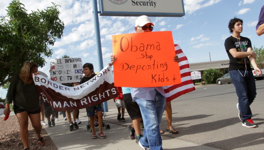 Marchers held signs as they made their way to Department of Homeland Security offices, protesting immigration policies Thursday, July 10, 2014.