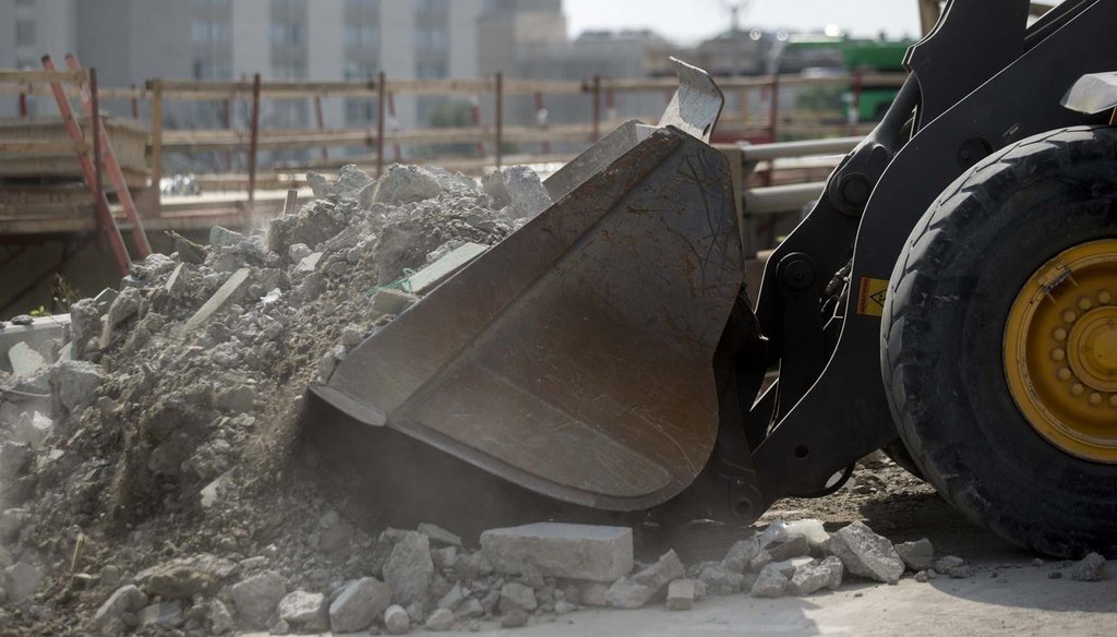 A wheel loader scoops debris from the Seminary Road overpass being demolished above Interstate 395 during a Virginia Department of Transportation project in Alexandria, Va., in 2015. (Bloomberg/Andrew Harrer)