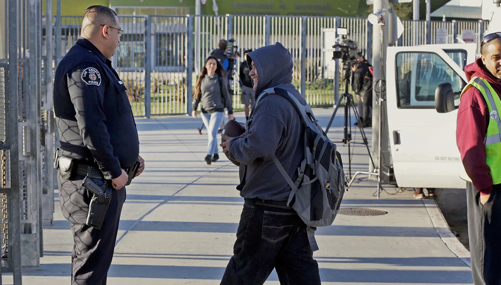 Los Angeles School Police officer Alex Camarillo, left, welcomes area students back to school at the Edward R. Roybal Learning Center in Los Angeles on Dec. 16, 2015. (AP)