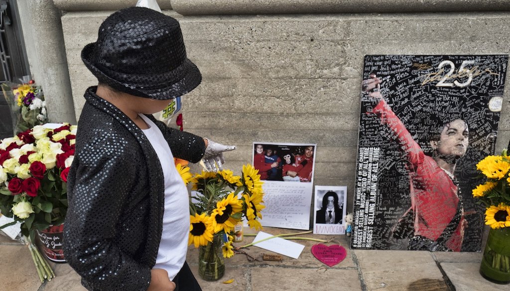 A young fan dances in front of Michael Jackson's mausoleum after coming to pay tribute to the singer during the 10th Anniversary of Jackson's death in front of the singers mausoleum at Forest Lawn Cemetery In Glendale, Calif. on June 25, 2019. (AP)