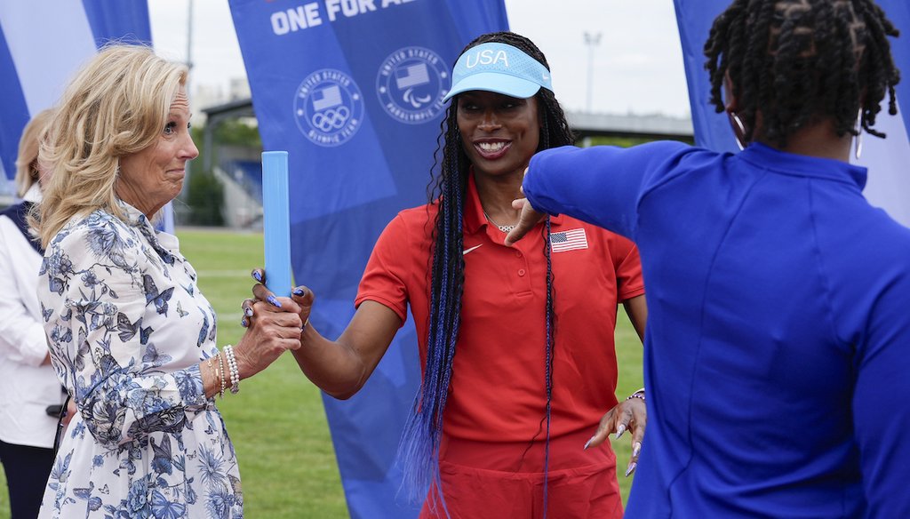 First lady Jill Biden, left, learns the proper technique to pass a baton from head women's relay coach Mechelle Freeman, center, of USA track and field, during a visit to the team's training facility, July 25, 2024, in Eaubonne, France. (AP)