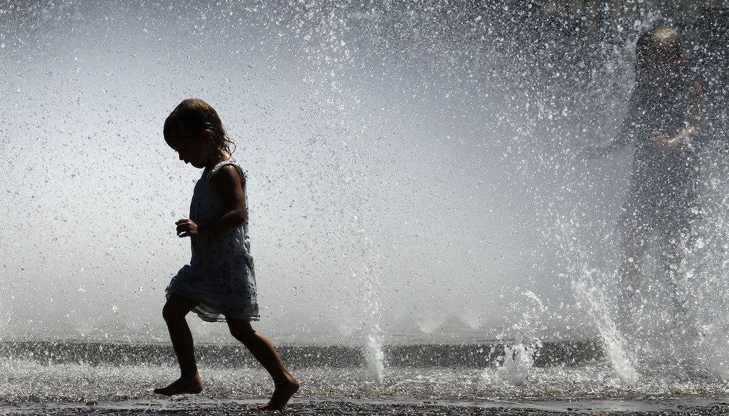 A young child frolics in a fountain in Portland, Ore., on July 31, 2015. (AP)