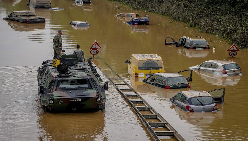 German army soldiers check for victims in flooded cars on a road in Erftstadt, Germany, after strong rainfall caused the Erft river to overflow, causing massive damage. (AP Photo/Michael Probst)