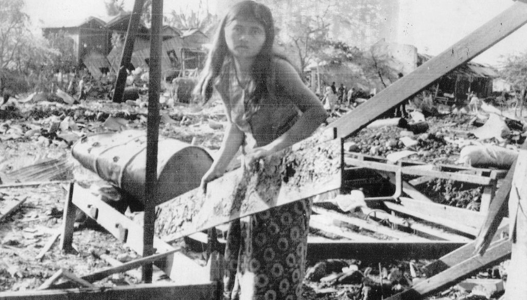 A Cambodian girl salvages a board from her home in Neak Luong, southeast of Phnom Penh, which was hit by a misdirected U.S. bombing raid. (Tampa Bay Times files)