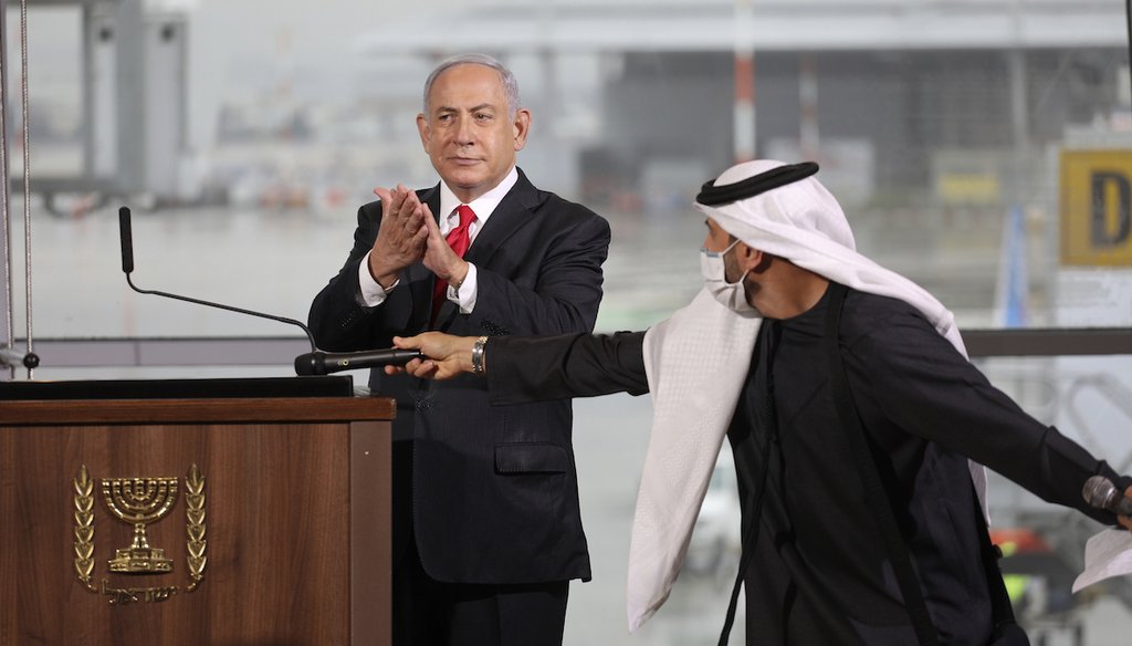 Israeli Prime Minister Benjamin Netanyahu uses hand sanitizer during a welcoming ceremony Nov. 26, 2020, for the first flydubai commercial flight to arrive at Ben Gurion International Airport in Tel Aviv. (AP)