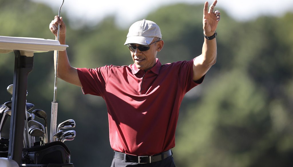 Then president Barack Obama waves as he puts a club away while golfing Aug. 14, 2015, at Farm Neck Golf Club, in Oak Bluffs, Mass., on the island of Martha's Vineyard. Bandages or golfers' tape can be seen on two fingers on his left hand. (AP)