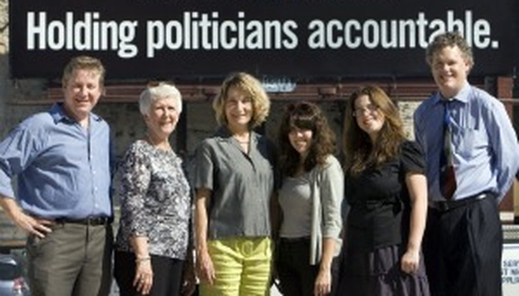 Members of the original PolitiFact Texas team pause before a billboard (American-Statesman photo, Deborah Cannon).