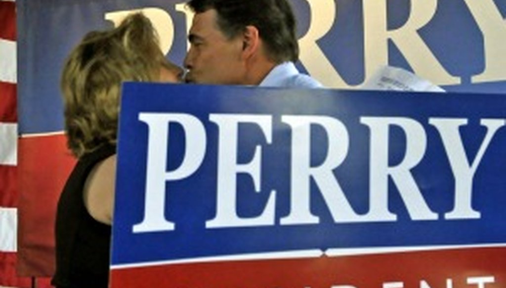 Gov. Rick Perry busses his wife, Anita, at an August campaign stop (Associated Press photo).