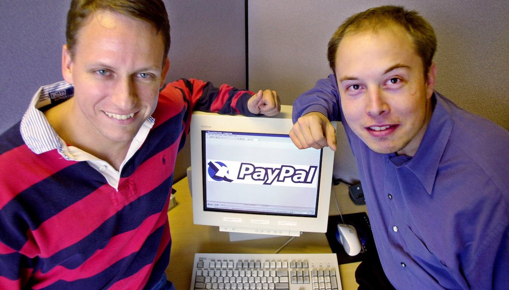 PayPal co-founders Peter Thiel, left, and Elon Musk pose with the PayPal logo at corporate headquarters in Palo Alto, Calif., Oct. 20, 2000. (AP)