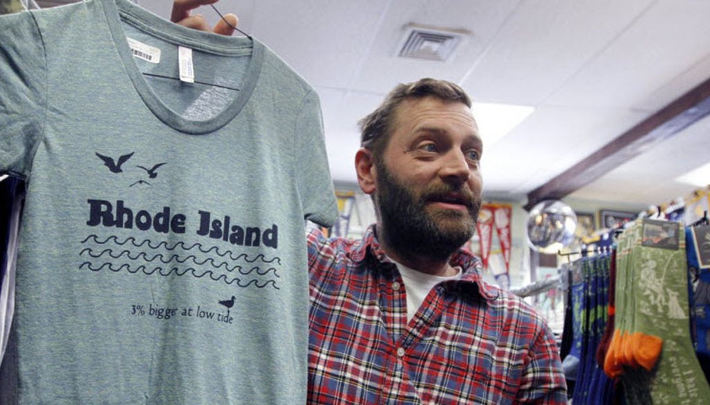 Asher Schofield, designer and co-owner of Frog and Toad holds up a shirt with a RI logo design by artist/designer Hilary Treadwell.